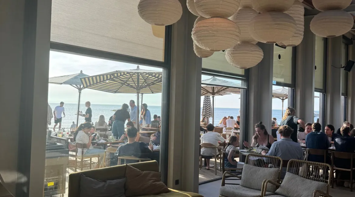 Luxe loungehoek van Republiek Bloemendaal met uitzicht op het strand en moderne verlichting