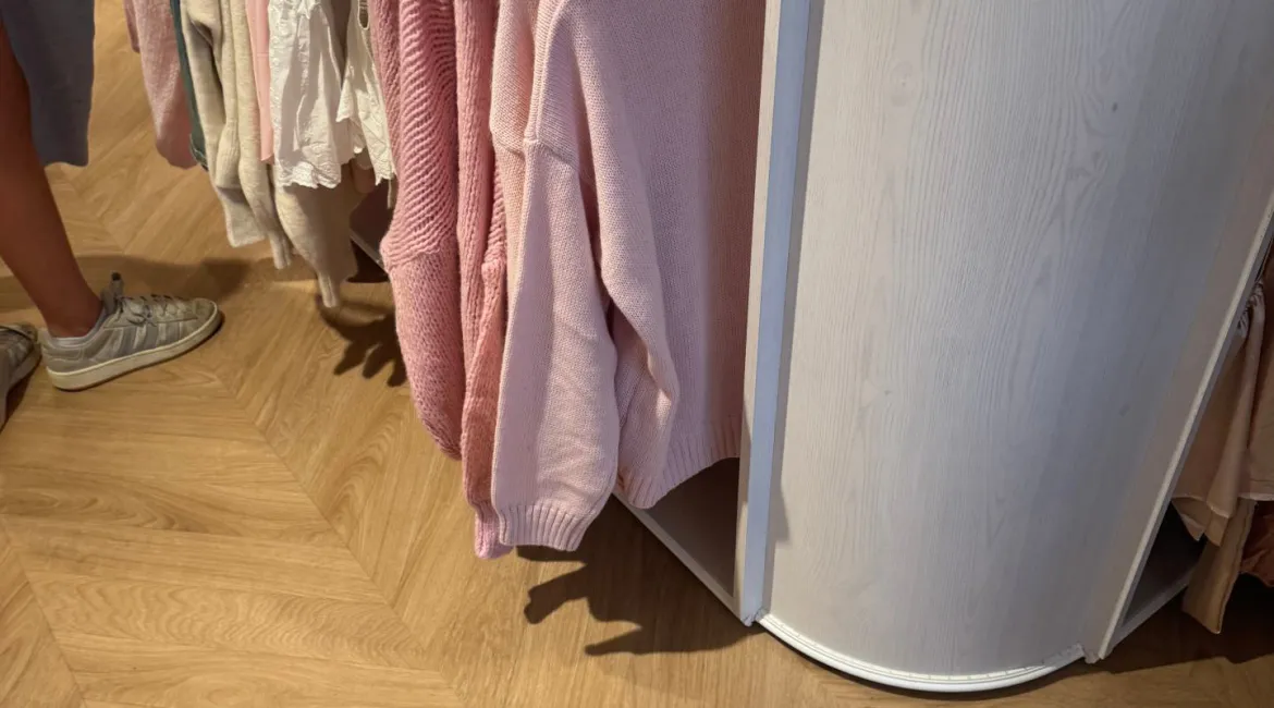 Interieur van Meet Me There in Breda met witte kasten, gouden details en opgevouwen kleding en sieraden