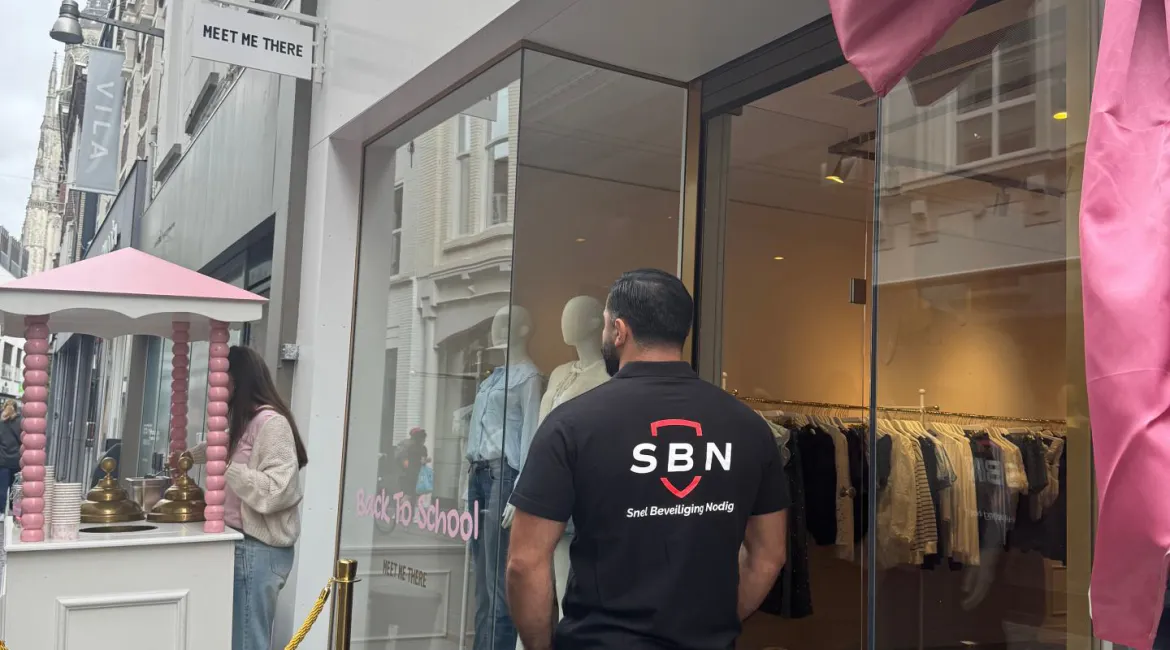 Ingang van Meet Me There in Breda tijdens de opening, met roze decoratie en bezoekers buiten de winkel